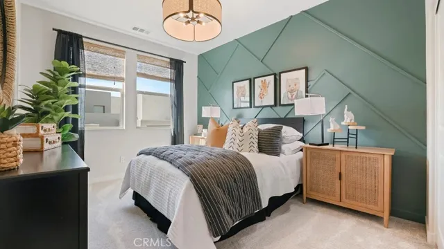 a bedroom with a bed lamp and a large window