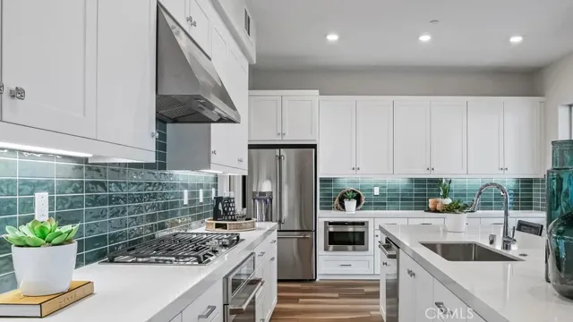 a kitchen with stainless steel appliances kitchen island granite countertop a stove a sink and a refrigerator
