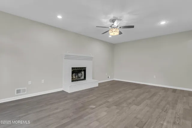 an empty room with fan and a fireplace