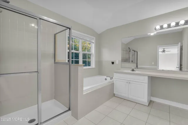 a bathroom with a tub sink shower and mirror