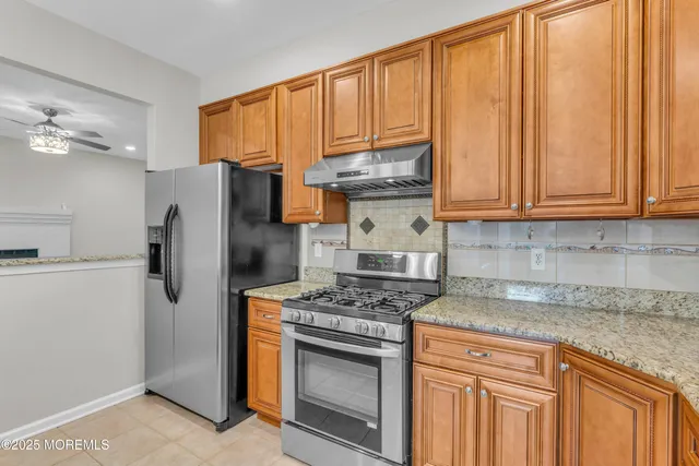 a kitchen with stainless steel appliances granite countertop a refrigerator stove and sink