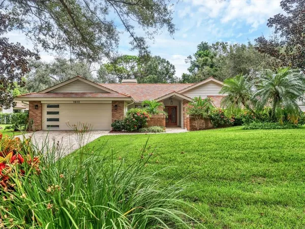 a front view of a house with yard and green space