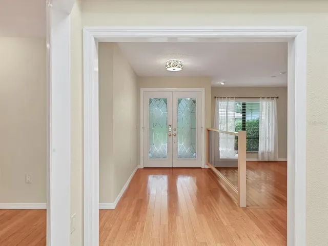 a view of a hallway with wooden floor and a living room
