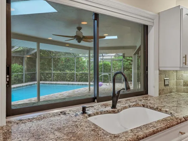a bathroom with a granite countertop sink and a large window