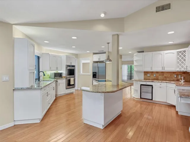 a large kitchen with stainless steel appliances and white cabinets