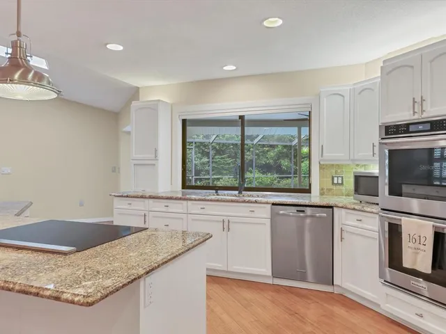 a kitchen with granite countertop a sink and a stove top oven