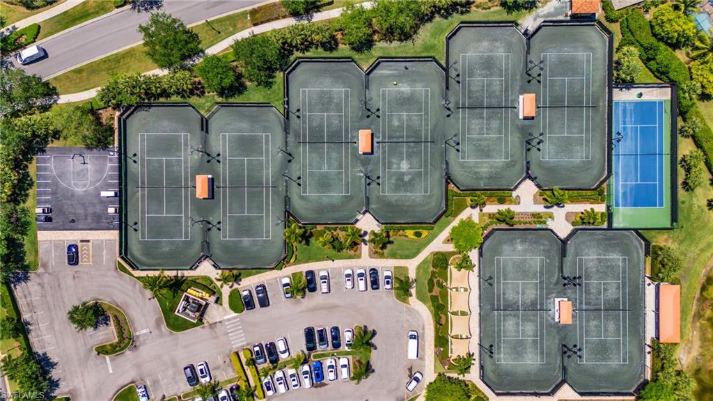 9479 Piacere Way Naples, FL 34113 - Photo 46 of 48 Multiple tennis courts, a basketball court, and vehicle parking areas within a landscaped setting