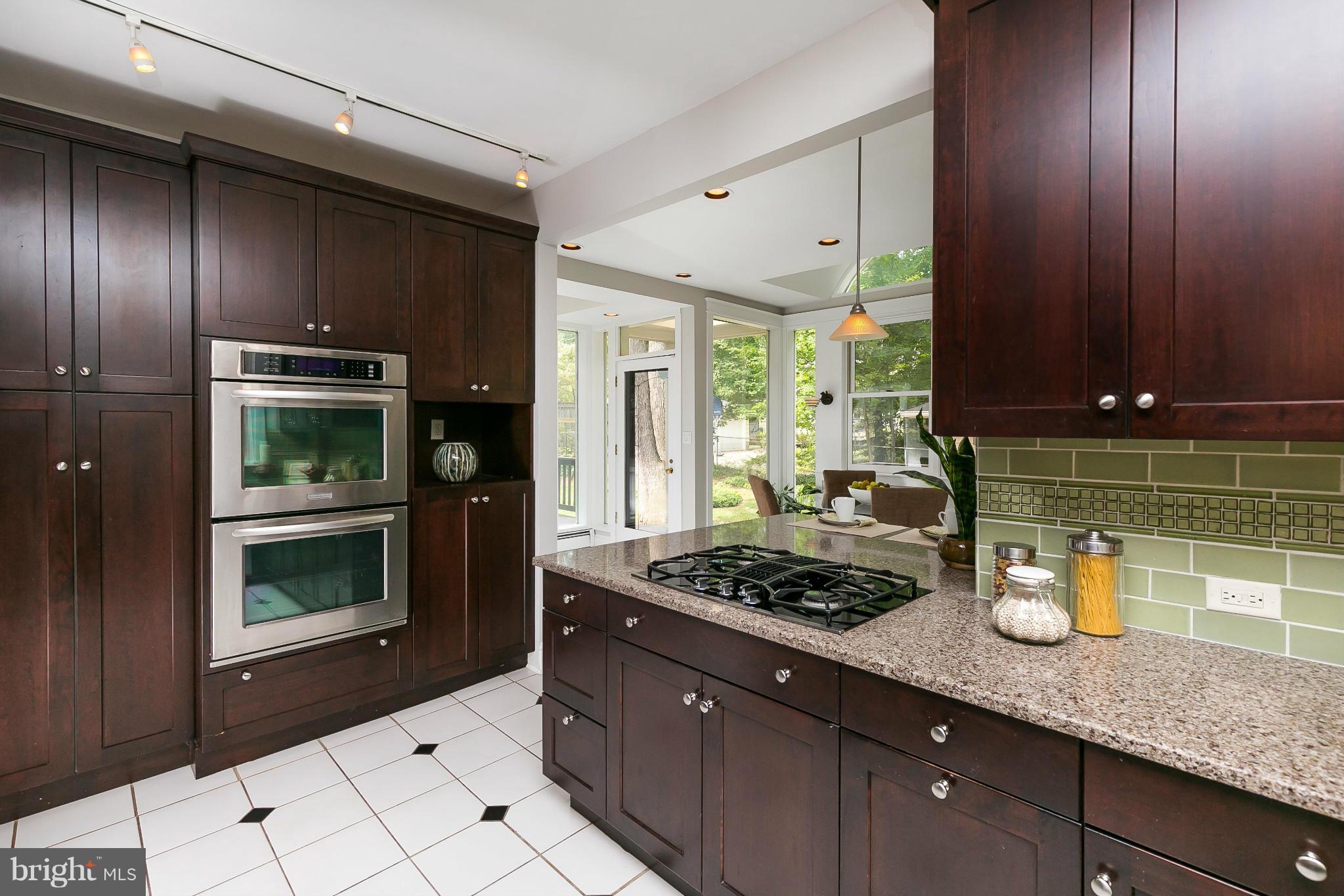 2306 Ken Oak Road Baltimore, MD 21209 - Photo 11 of 30 a kitchen with a stove a microwave and wooden cabinets