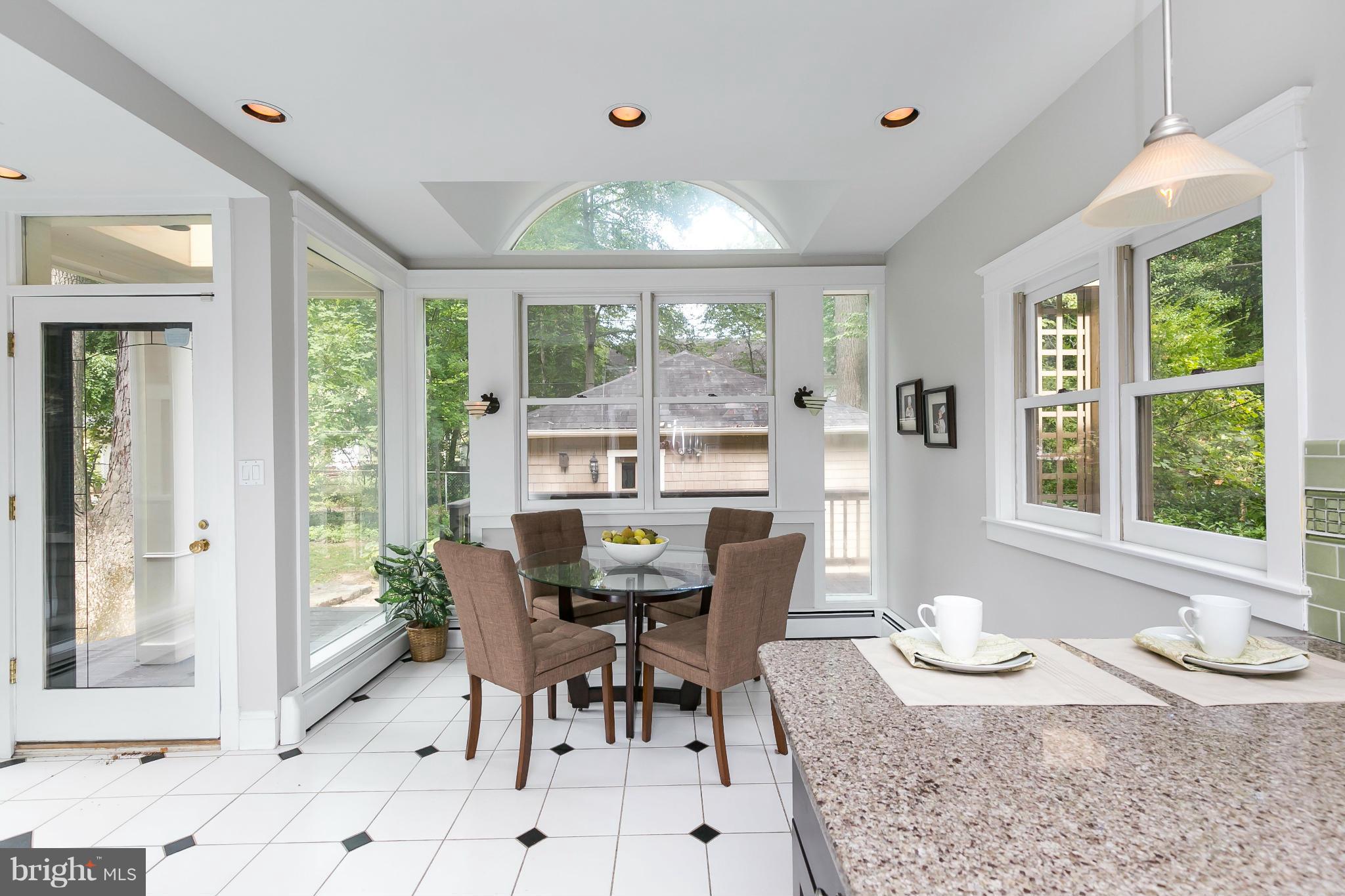 2306 Ken Oak Road Baltimore, MD 21209 - Photo 12 of 30 a dining room with furniture a rug a potted plant and a chandelier