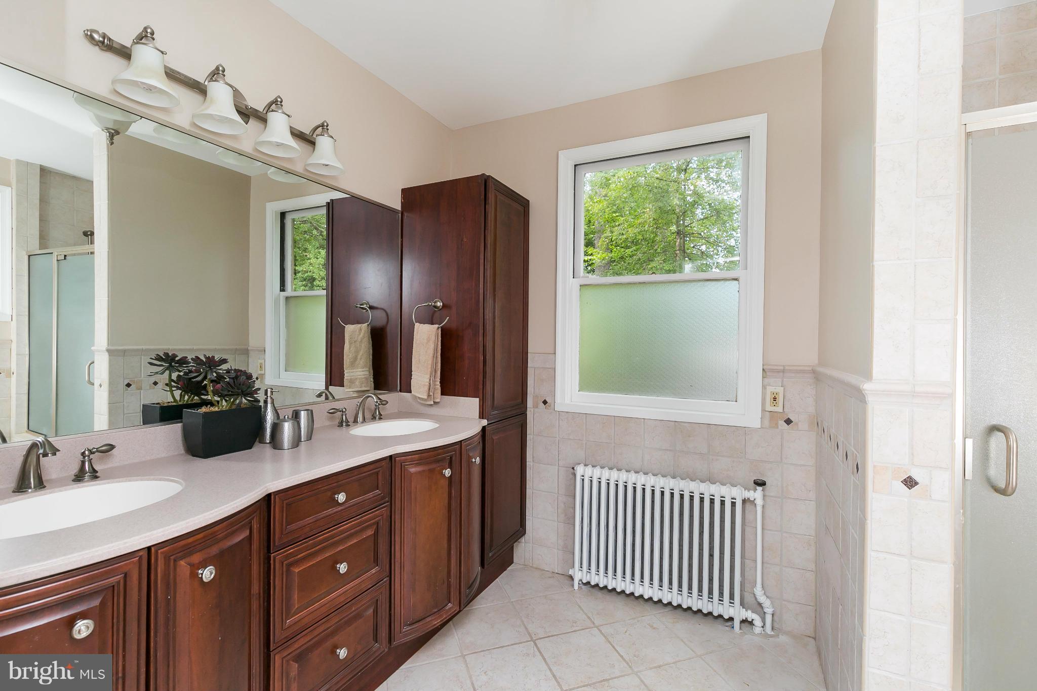 2306 Ken Oak Road Baltimore, MD 21209 - Photo 20 of 30 a bathroom with a double vanity sink and a mirror