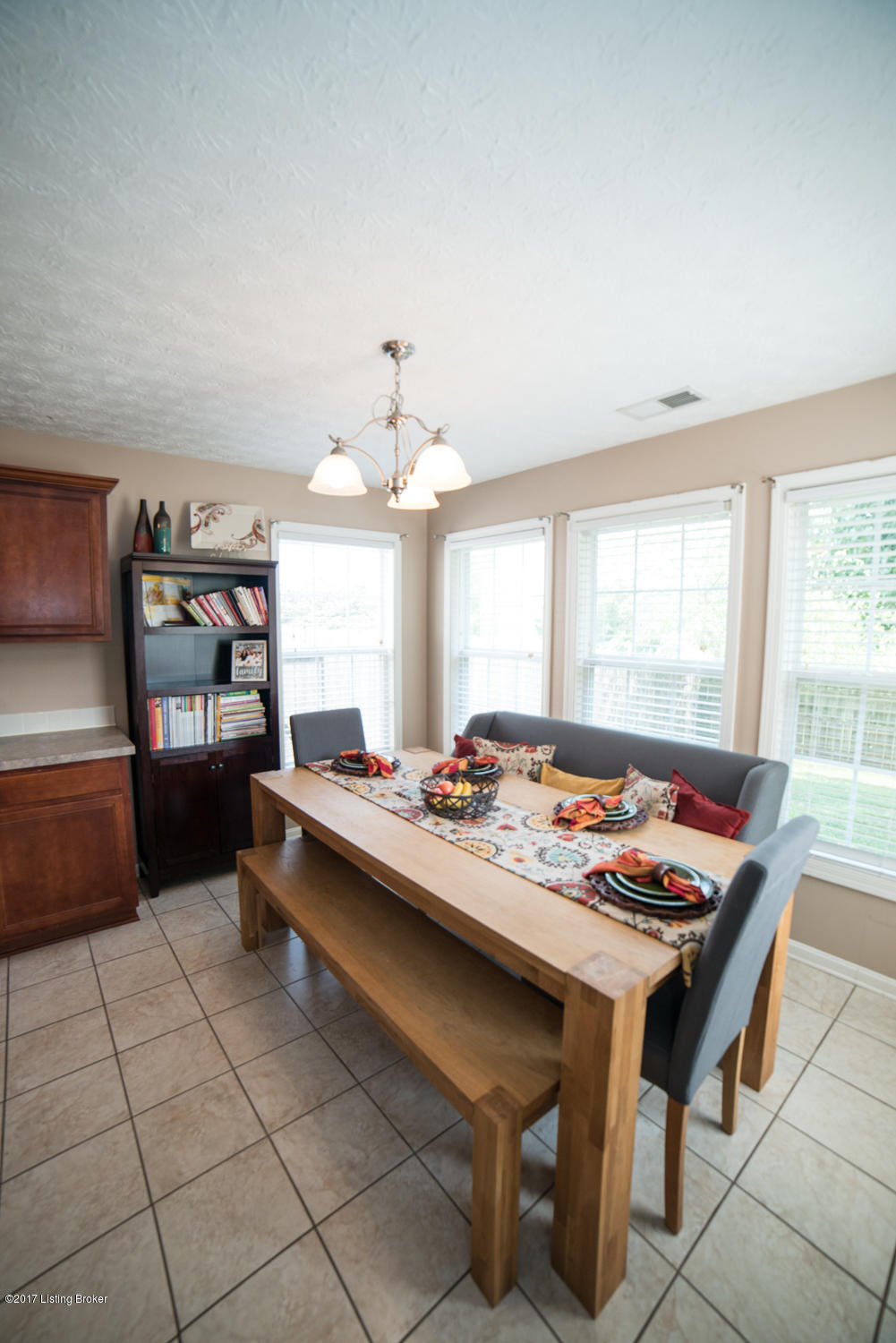 17520 Curry Branch Road Louisville, KY 40245 - Photo 13 of 45 The dining area is well lit with an overhead chandelier and natural light from the wall of windows