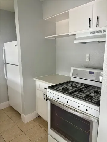 a stove top oven sitting inside of a kitchen