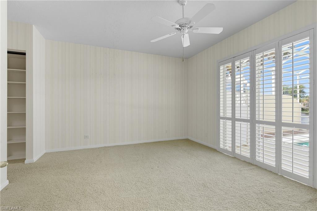 5925 Bermuda Lane Naples, FL 34119 - Photo 12 of 24 Spare room with light colored carpet, a ceiling fan, and wallpapered walls