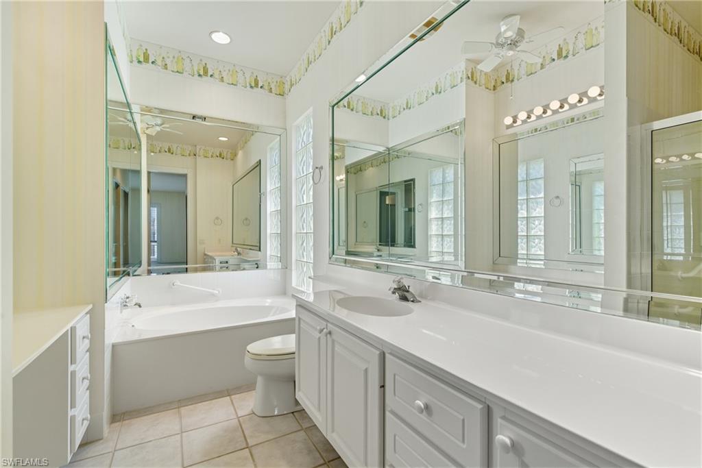 5925 Bermuda Lane Naples, FL 34119 - Photo 16 of 24 Bathroom featuring a ceiling fan, a garden tub, vanity, and light tile patterned floors