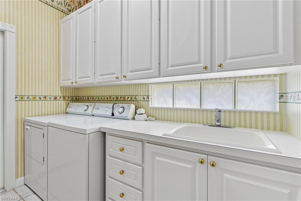 5925 Bermuda Lane Naples, FL 34119 - Photo 19 of 24 Laundry area featuring wallpapered walls, washing machine and clothes dryer, cabinet space, and light tile patterned floors