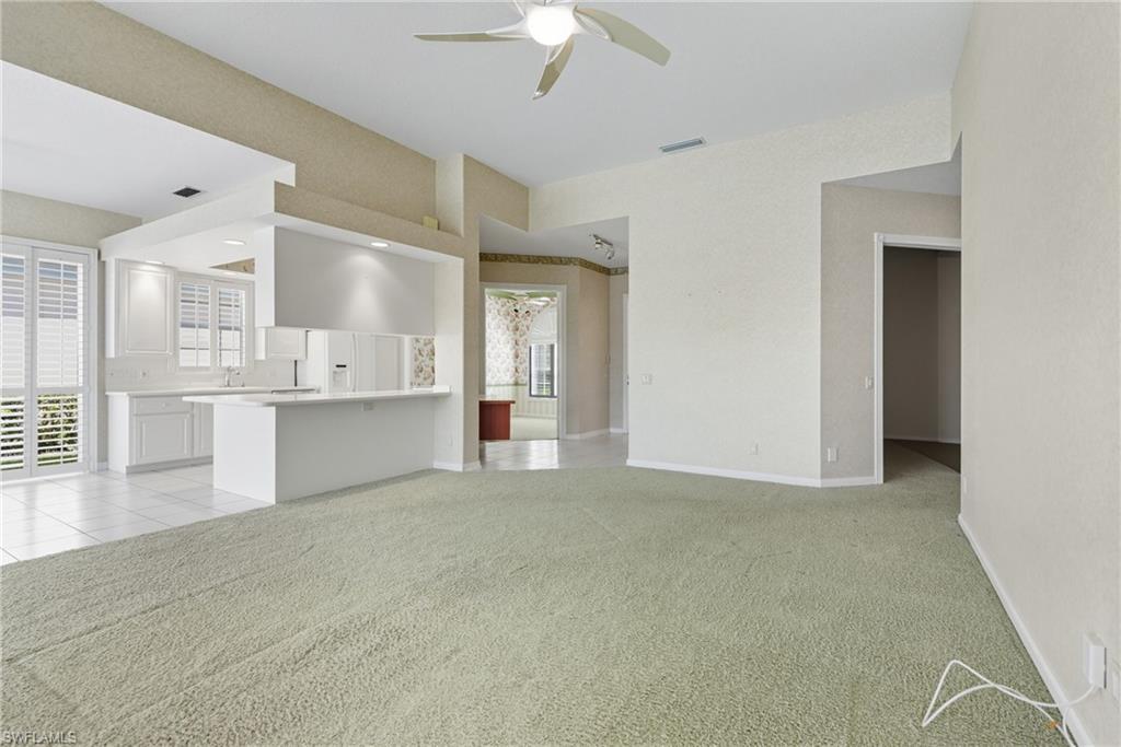 5925 Bermuda Lane Naples, FL 34119 - Photo 4 of 24 Unfurnished living room featuring light carpet, ceiling fan, and light tile patterned floors