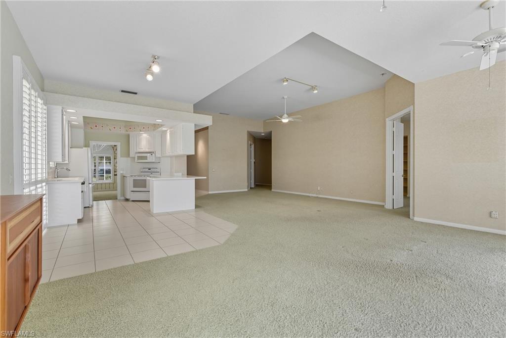5925 Bermuda Lane Naples, FL 34119 - Photo 6 of 24 Unfurnished living room featuring light tile patterned floors, ceiling fan, and light colored carpet
