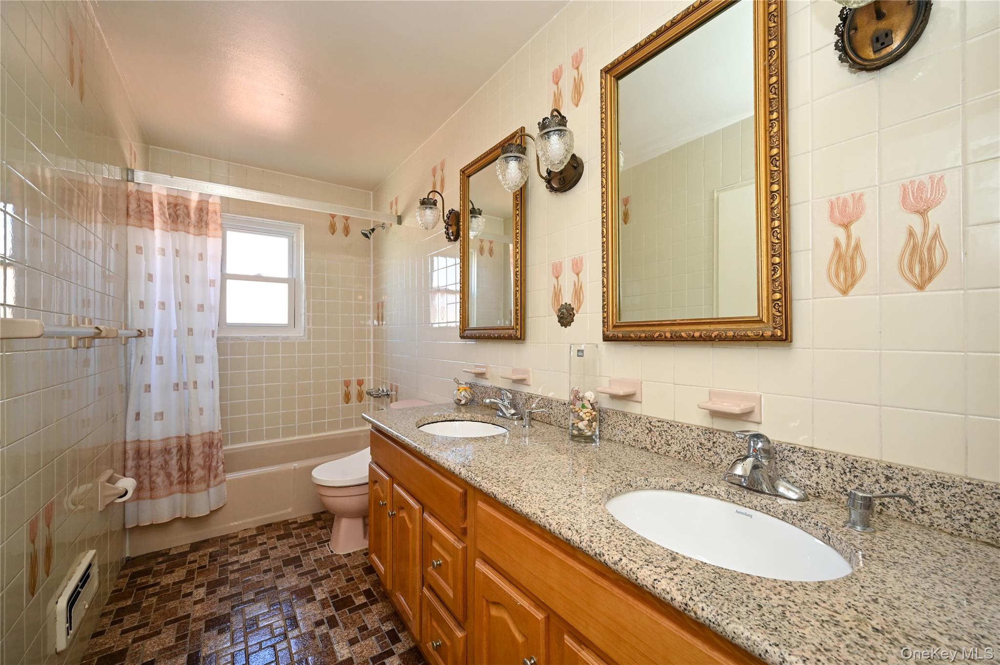 28-30 210th Street Queens, NY 11360 - Photo 11 of 19 Full bath with tile walls, shower / bath combination with curtain, double vanity, and a baseboard heating unit