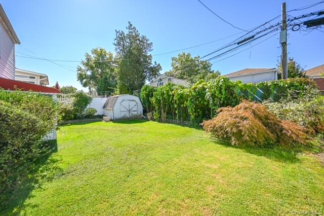 28-30 210th Street Queens, NY 11360 - Photo 19 of 19 Fenced backyard featuring a storage unit