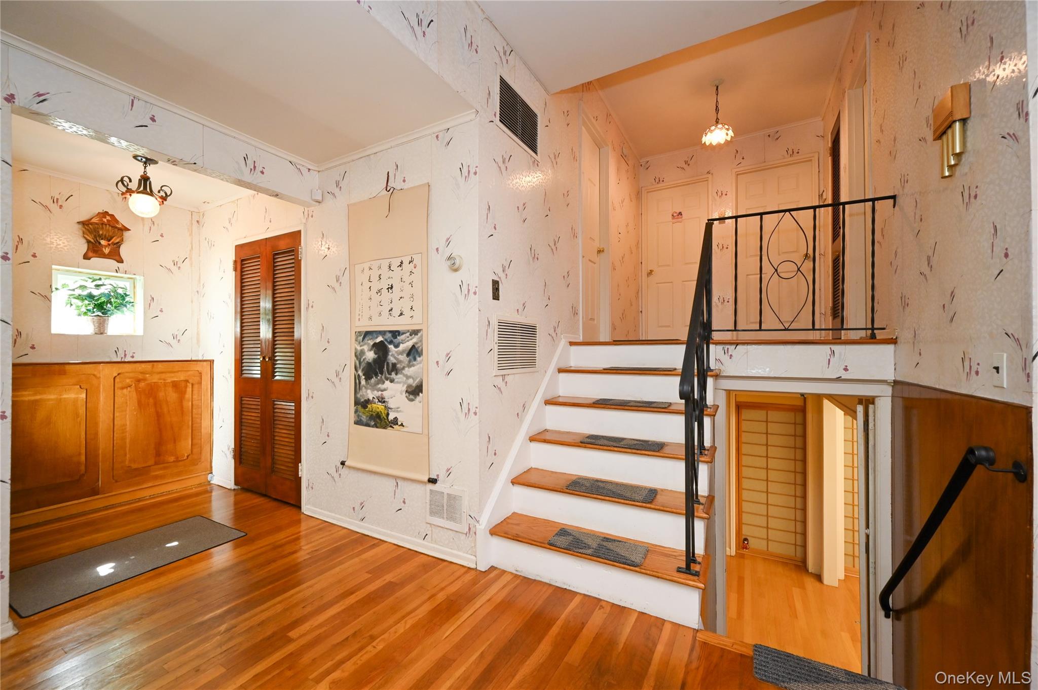 28-30 210th Street Queens, NY 11360 - Photo 4 of 19 Staircase featuring wallpapered walls and wood finished floors