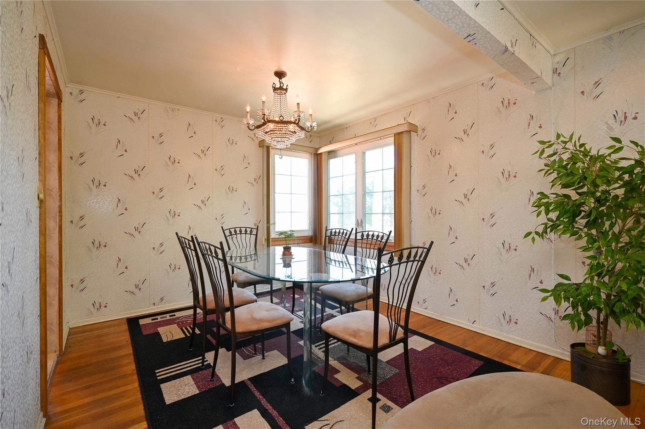 28-30 210th Street Queens, NY 11360 - Photo 5 of 19 Dining space with wallpapered walls, wood finished floors, a chandelier, beam ceiling, and crown molding
