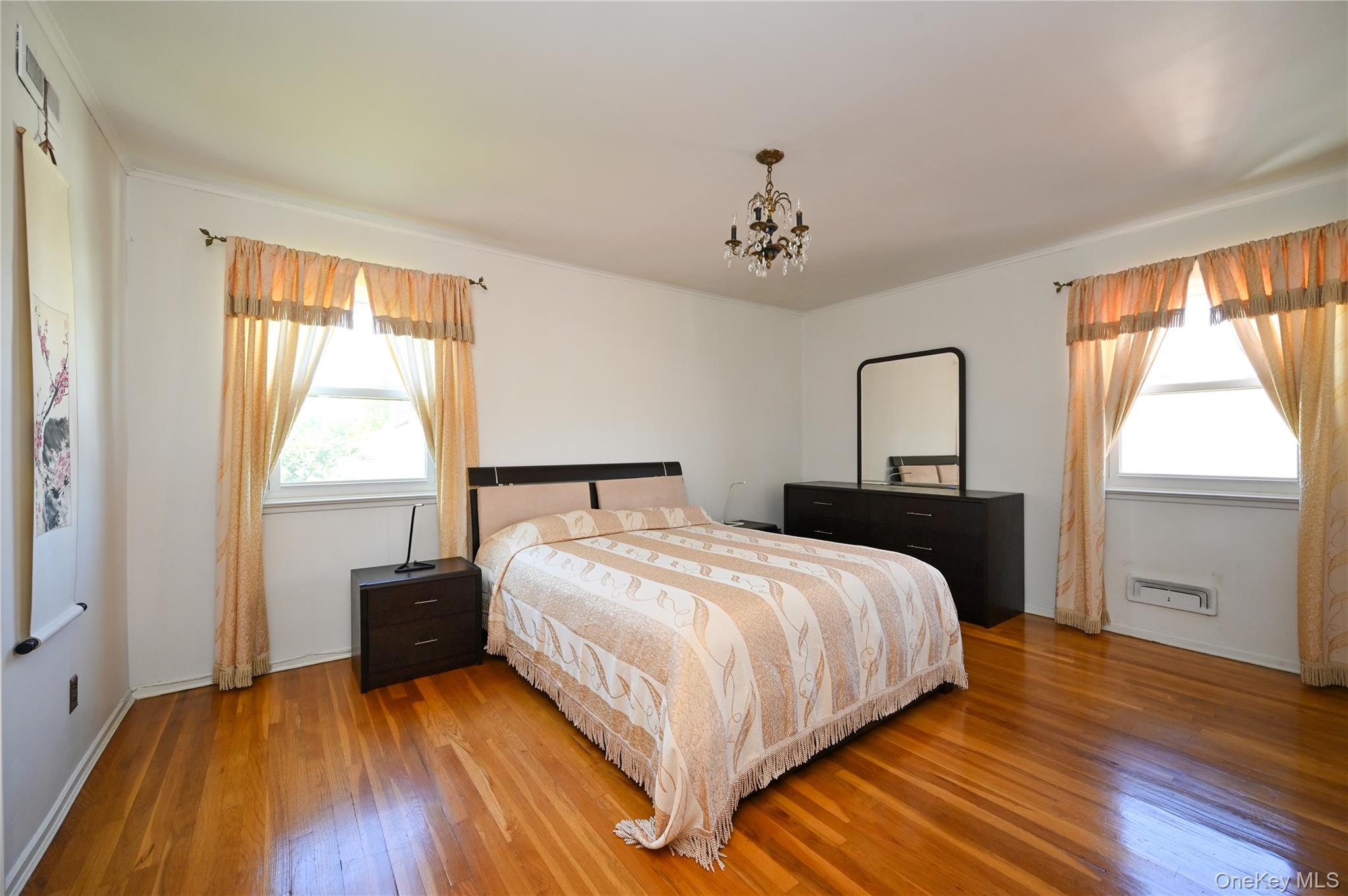 28-30 210th Street Queens, NY 11360 - Photo 7 of 19 Bedroom with wood-type flooring and a chandelier