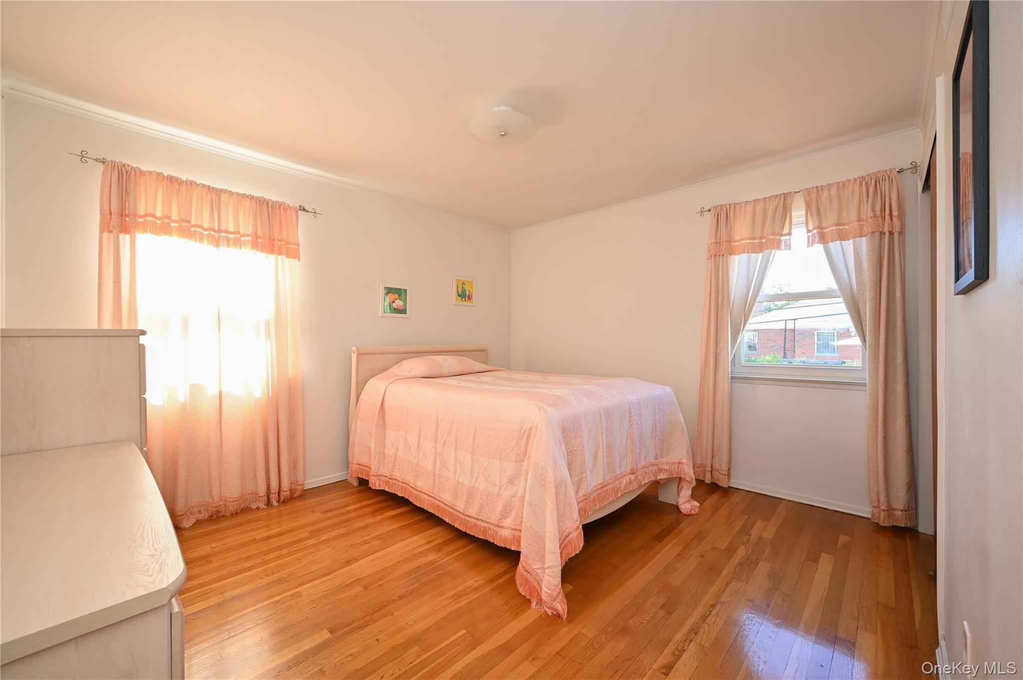 28-30 210th Street Queens, NY 11360 - Photo 8 of 19 Bedroom featuring light wood-style flooring and multiple windows