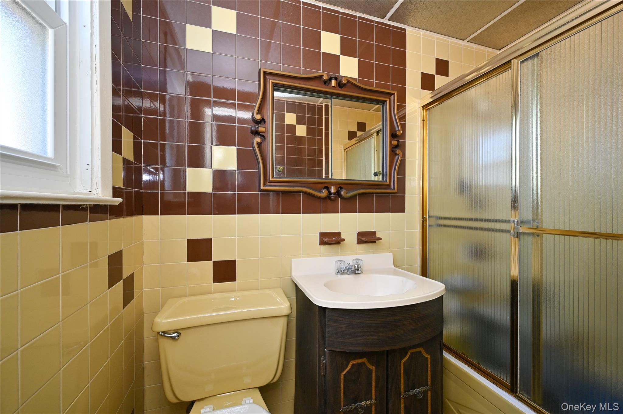 28-30 210th Street Queens, NY 11360 - Photo 9 of 19 Full bath with tile walls, vanity, decorative backsplash, and enclosed tub / shower combo