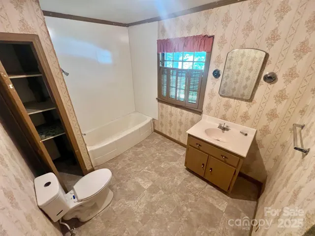a bathroom with a tub sink toilet and mirror