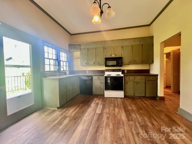 a kitchen with stainless steel appliances granite countertop a sink cabinets and wooden floor
