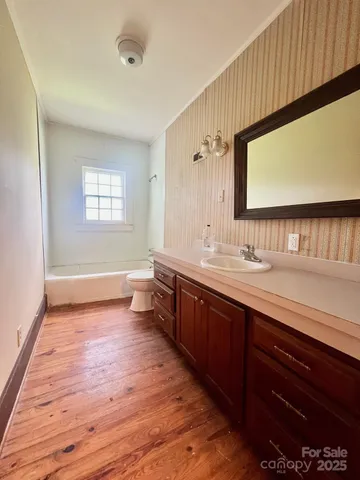 a bathroom with a tub sink and mirror