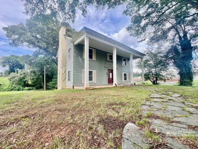 a view of a house with backyard and a tree