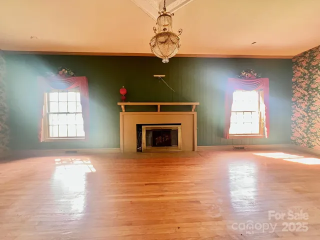 a view of empty room with wooden floor and fireplace