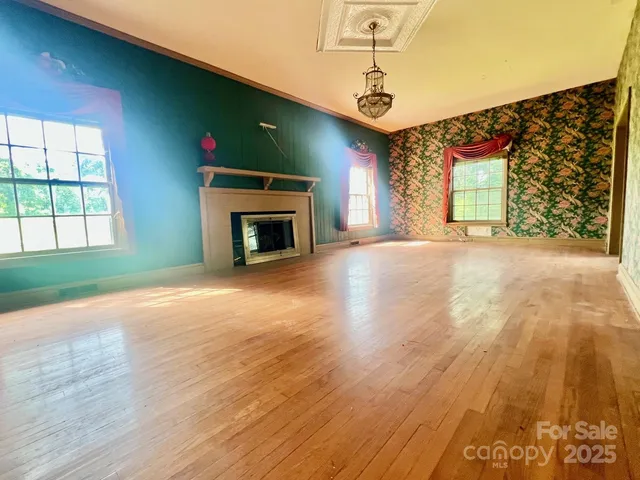 a view of an empty room with a fireplace and a window