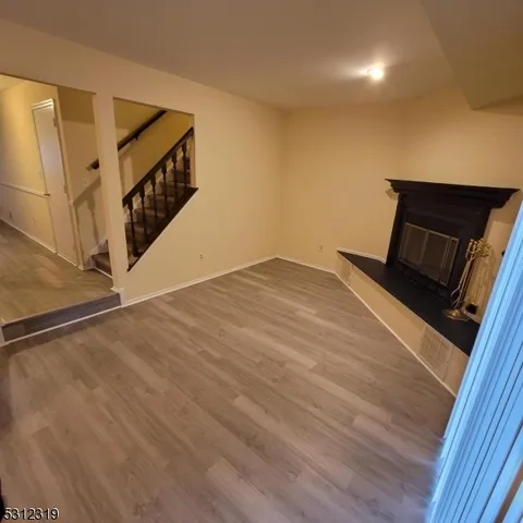 a view of a livingroom with wooden floor and stairs