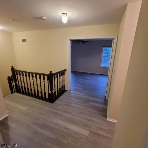 a view of a hallway with wooden floor