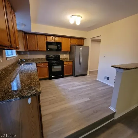 a kitchen with stainless steel appliances granite countertop a refrigerator and a stove
