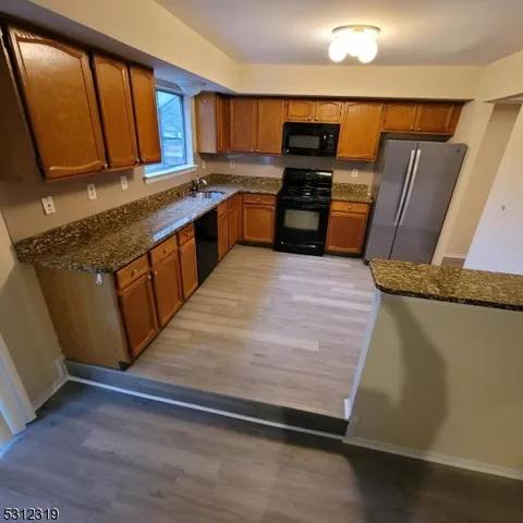 a kitchen with stainless steel appliances granite countertop a stove a sink and a refrigerator
