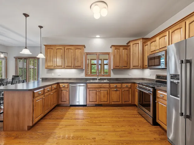 a kitchen with stainless steel appliances granite countertop a sink a stove top oven a counter space and cabinets