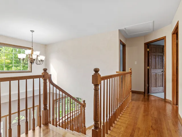 a view of a hallway with wooden floor and windows