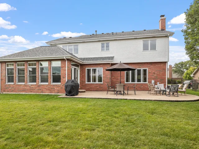a view of a house with a yard and sitting area