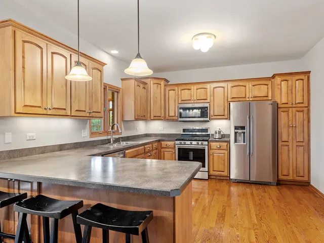 a kitchen with stainless steel appliances granite countertop a stove refrigerator sink and cabinets