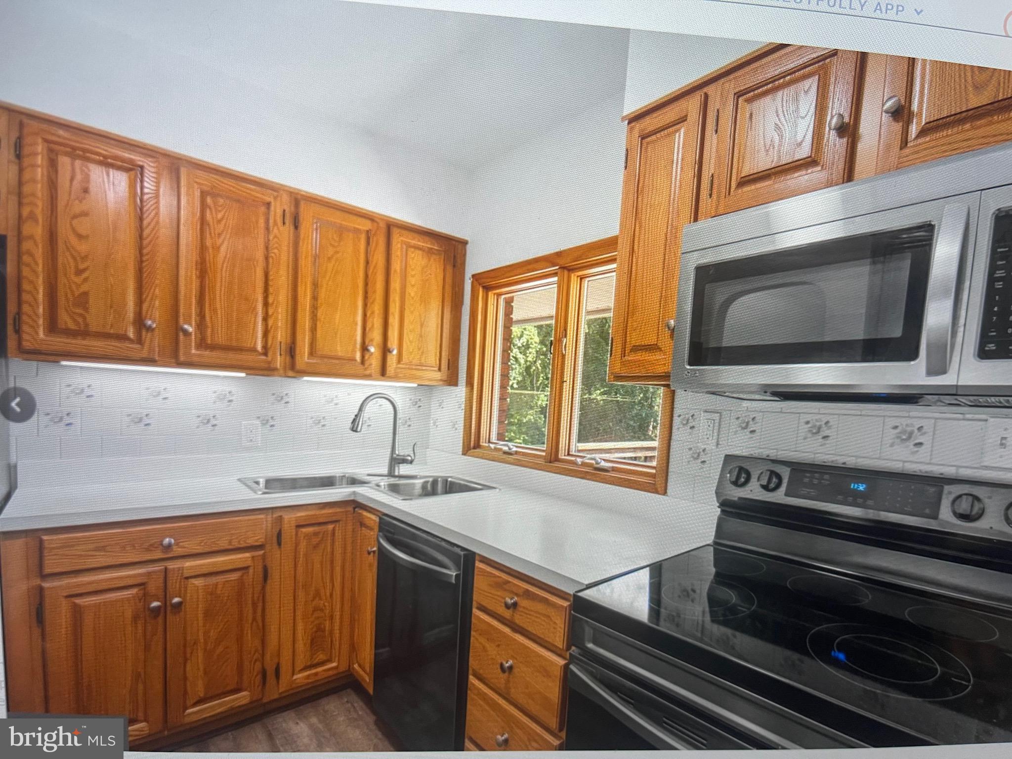 8608 Inwood Road Windsor Mill, MD 21244 - Photo 17 of 20 a kitchen with stainless steel appliances granite countertop a stove microwave and cabinets