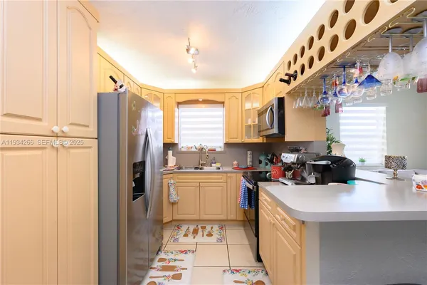 a kitchen with a sink a refrigerator and cabinets