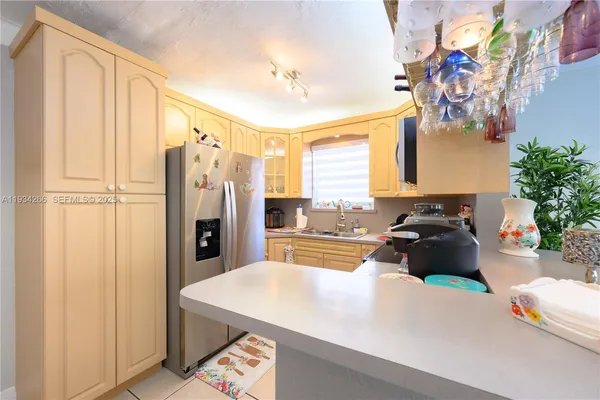 a kitchen with stainless steel appliances a refrigerator a sink a stove and a window