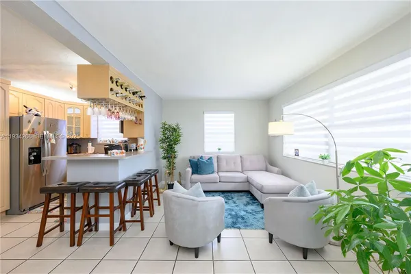 a living room with furniture a window and a potted plant