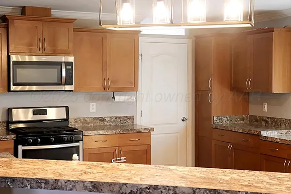 a kitchen with granite countertop a stove and a microwave