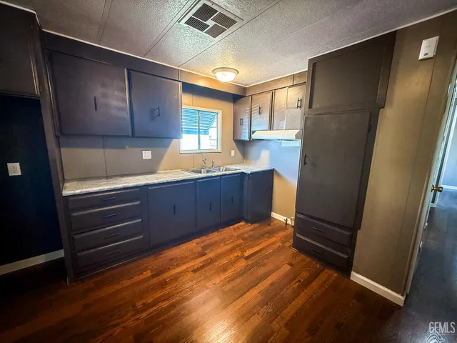 a view of kitchen with wooden floor and electronic appliances
