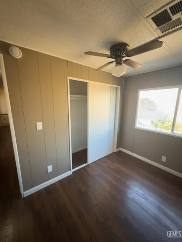 an empty room with windows and fan