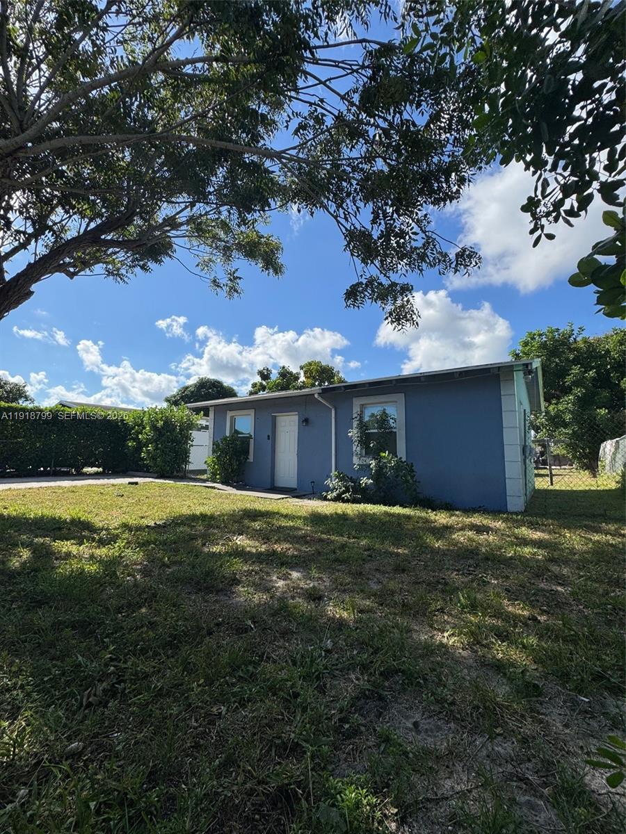218 Southwest 11th Avenue Delray Beach, FL 33444 - Photo 2 of 7 a front view of a house with a garden and yard